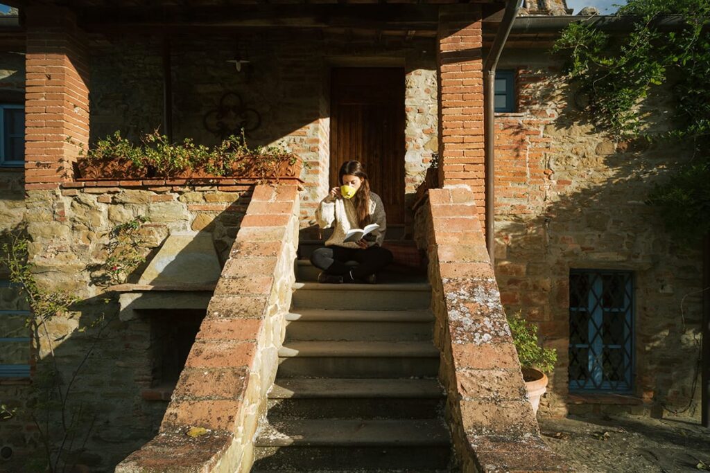 woman sipping coffee sitting on stairs