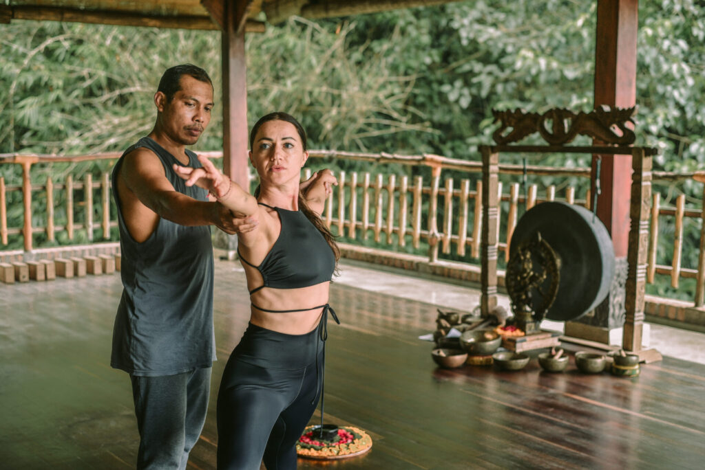 woman doing yoga with teacher