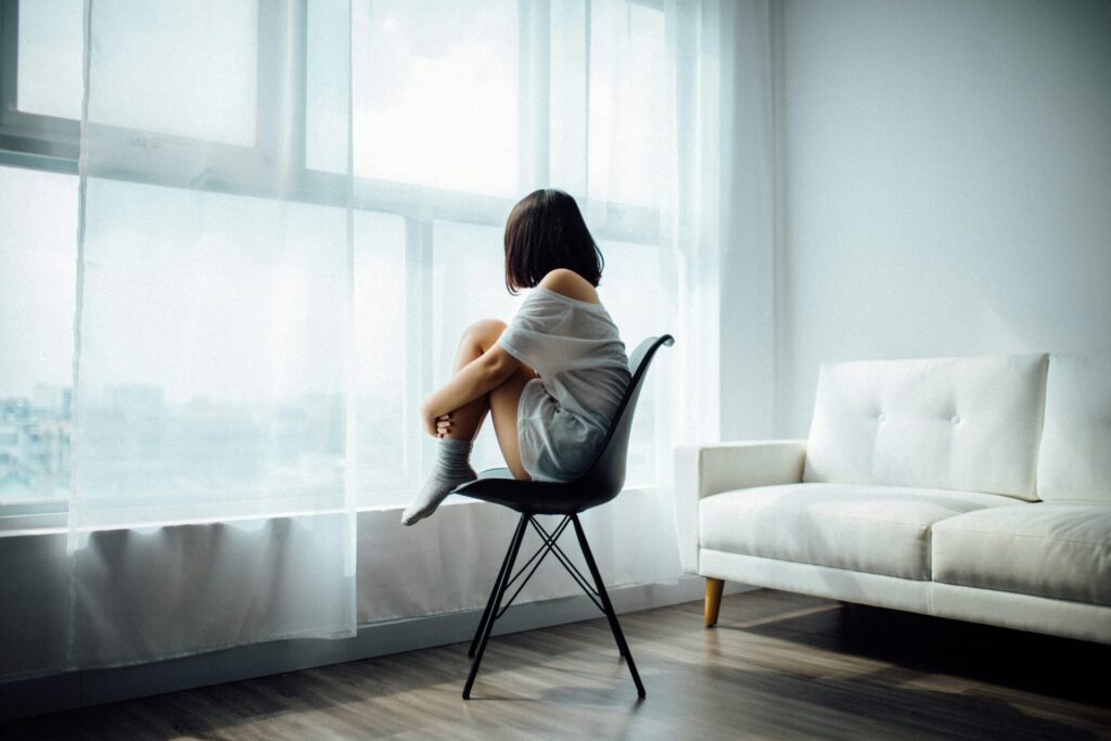 woman sitting on a chair contemplating the outside world 