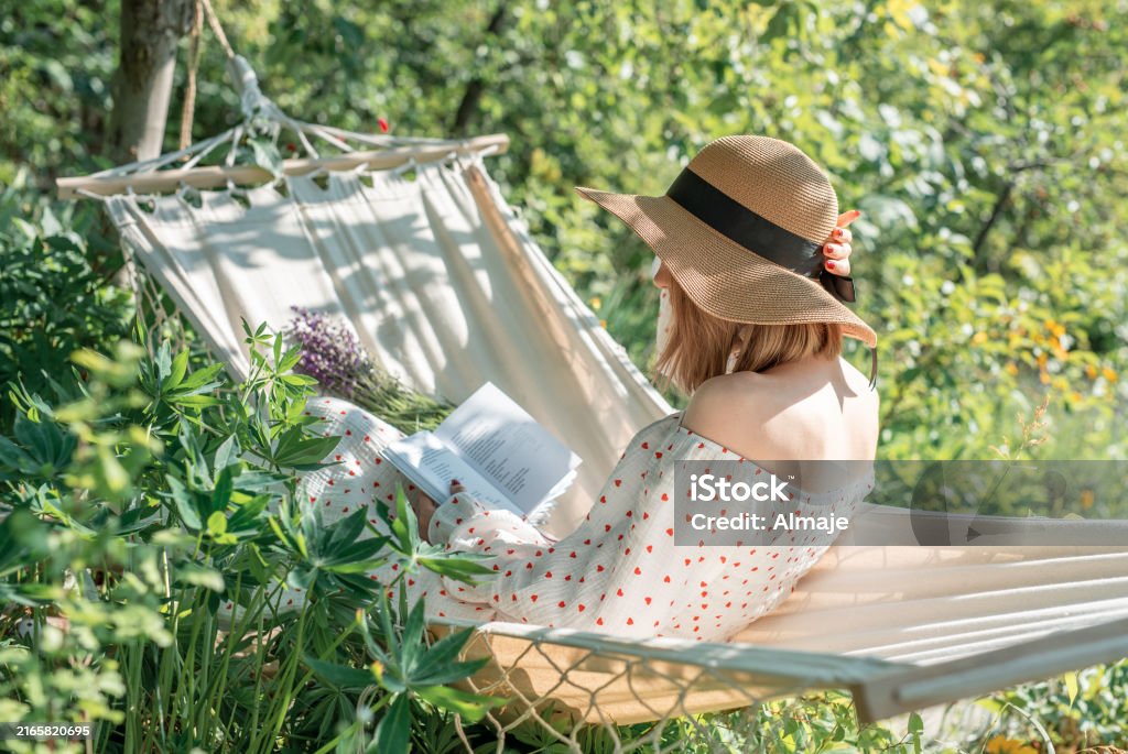 woman reading a book on a hammock